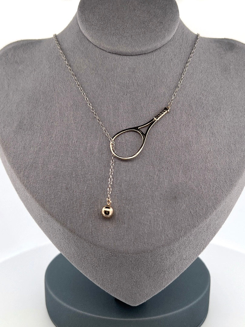 The newest design by Adeline - this unusual necklace is a tennis lovers delight.   The solid gold ball threads through the racket and can be worn higher or lower on the neck.  This piece was hand made in the jewelry district of Los Angeles by a fine jewel craft team.  The racket is 1.5