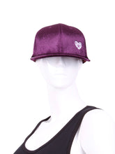Load image into Gallery viewer, The Purple Velvet Tennis Hat exudes a unique blend of elegance and sporty charm. Crafted from a plush and rich purple velvet material, this hat sets itself apart with its luxurious texture and vibrant color. The velvet fabric catches the light in a way that creates subtle shifts in hue, adding depth to the overall appearance.
